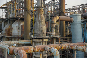 Old Factory metal structures. Industrial plant with old, rusty pipes and cooling tower for cooling...