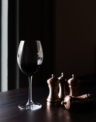 A glass of red wine and chess pieces