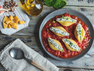 pasta conchiglioni stuffed spinach and cheese, tomato sauce on plate ,cooked