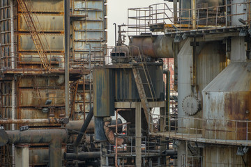 Old Factory metal structures. Industrial plant with old, rusty pipes and cooling tower for cooling water supply. Beijing, China.
