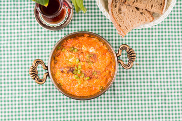 Turkish breakfast menemen. Tea and bread on green table