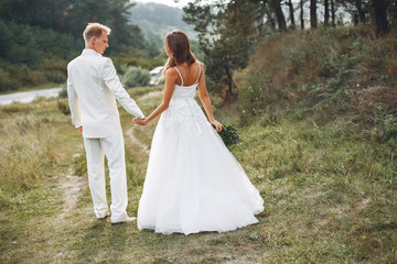 Beautiful wedding couple in a summer field