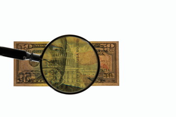 Close up view of magnifying glass over fifty dollar bill. Banknote. Beautiful backgrounds.