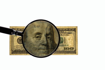 Close up view of magnifying glass over hundred dollar bill. Banknote. Beautiful backgrounds.