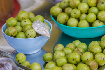 Indian gooseberry (Phyllanthus emblica), also known as emblic, emblic myrobalan, myrobalan, Indian gooseberry, Malacca tree, or amla fruit. Emblic fruits for sale in the fruit market, Thailand.