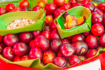 Red ramontchi fruits (Flacourtia indica) for sale at the local market in Chiang Rai, Thailand. Flacourtia indica also known as ramontchi, governor’s plum, batoko plum, Madagascar plum and Indian plum.