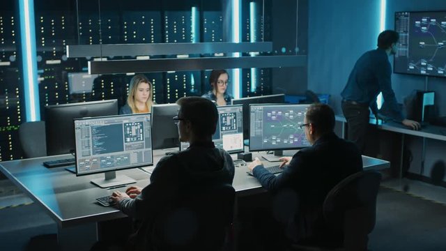 Team of IT Programers Working on Desktop Computers in Data Center Control Room. Young Professionals Writing on Sophisticated Programming Code Language. Elevated Moving Camera Shot