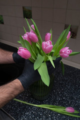 Pink flowers in the hands on the kitchen table 