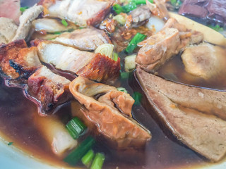 Chinese roll noodle soup or Kuay jub, one of Thai street food that contained noodles roll, pork livers, pork blood, pork kidney, boiled eggs and meat. Large bowl of delicious Chinese roll noodle soup.