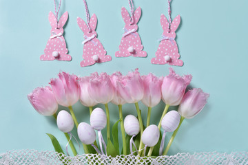 easter flat lay with pink tulips and decors on mint background