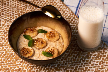 Breakfast oatmeal porridge bowl with banana and caramel, close-up