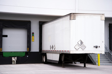 Semi trailer for big rig semi truck loading commercial cargo at warehouse dock with thermally insulated gate