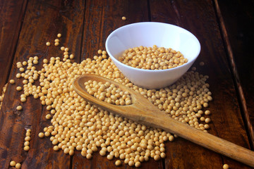 raw and fresh soy beans inside white ceramic bowl on rustic wooden table. Close up
