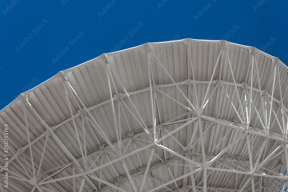 Wall mural very large array sweeping arch showing understructure of a large dish telescope against a blue sky, 
