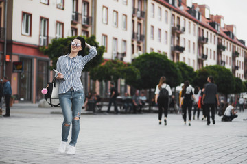Young brunette woman walking and relaxing in old city street