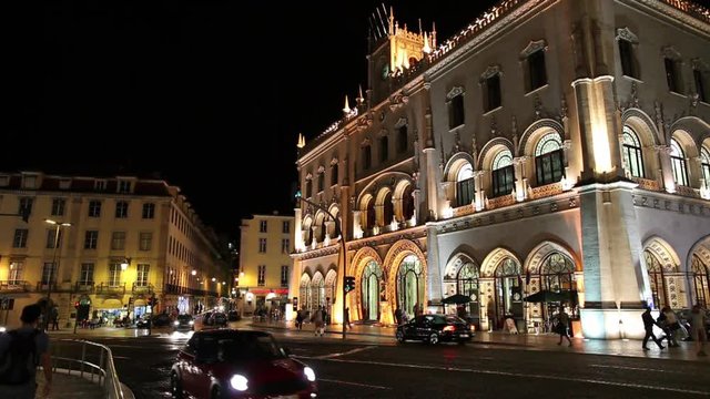 WS Traffic in front of Rossio railway station illuminated at night / Lisbon, Portugal