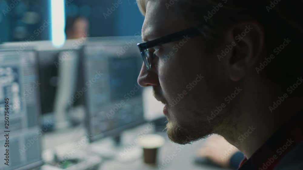 Poster Smart Male IT Programer Working on Desktop Computer in Data Center Technical System Control Room. Team of Young Professionals Programming in Coding Language