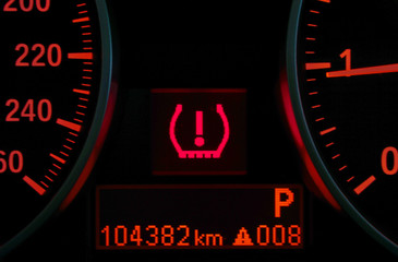 Closeup of lose tyre pressure alert in dashboard car on background.