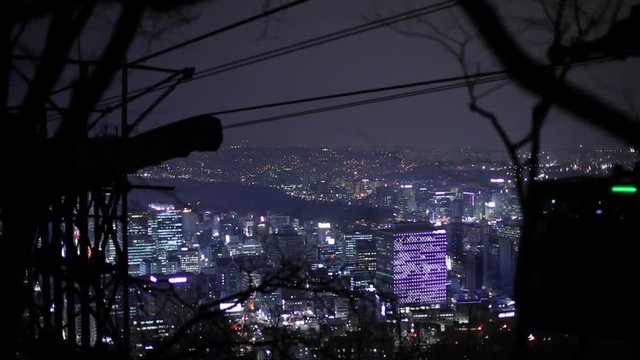 MS N Seoul Tower cable car with illuminated city at night in background / Seoul, South Korea