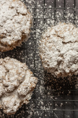 three cinnamon crumb muffins on a rack with powdered sugar on the black marble countertop vertical