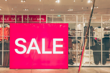 Sales promotion of women fashion clothes retail store in shopping mall, sale label sign sticker in front of shop door glasses..