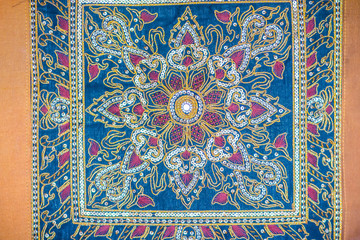 Seamless pattern on blue fabric background with white and orange elements. Classic Turkish textile ornament, mandala, kaleidoscope, vintage background.