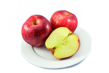Red apple fruit and apple slice half on plate isolated on white background