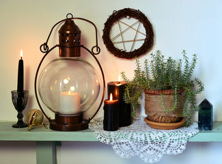 Old lamp, black candles, pentagram and succulent in pot. Magic gothic ritual. Wicca, esoteric, divination and occult background with vintage objects