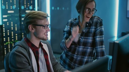 Male and Female Programmers Talking, Solving Problem, Using Computers, Doing High Five After Success. Software Development / Code Writing / Website Design / Database Architecture. Technical Department - Powered by Adobe