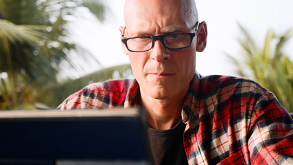 Portrait of handsome man working on laptop at open air coworking area