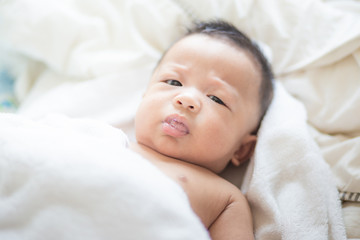 Asian baby boy lying on white blanket morning wake up