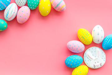 Fototapeta na wymiar Easter symbols. Colorful Easter eggs and gingerbread on pink background space for text