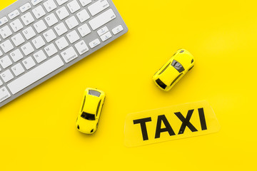 Taxi operator concept. Order taxi online. Sign ner car toy and keyboard on yellow background top...