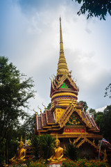 Fototapeta premium Beautiful golden pagoda with decorative Thai style fine art at public Buddhist Wat Phu Phlan Sung, Nachaluay, Ubon Ratchathani, Thailand.