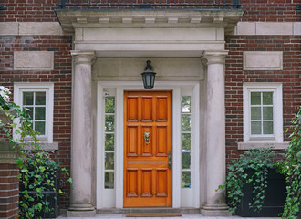 Fototapeta na wymiar elegant wooden front door and stone columns of portico entrance