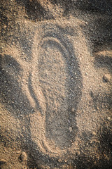 Shoe track on sand / Imprint footprint on ground traces of feet texture background