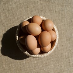 Bowl of eggs on brown sack background 