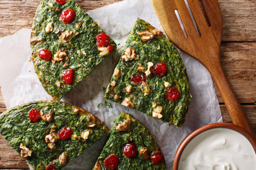 Persian kuku sabzi omelette of herbs, eggs and nuts closeup. Horizontal top view