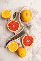 citrus fruits on table linen on marble background flat lay top view