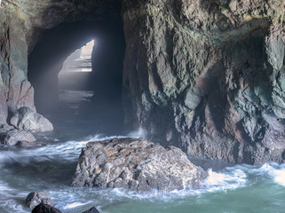 Cave by the ocean in rugged rocks.