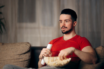 Man Watching TV Eating Pop Corn