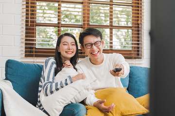 Obraz premium Asian couple lifestyle, man and woman watching TV movies at home, family lifestyle relax and recreation concept