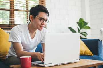 Young Asian man working with laptop at home