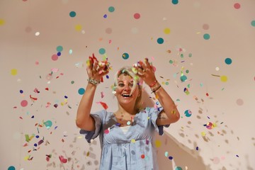 A young happy blond woman against colourful background