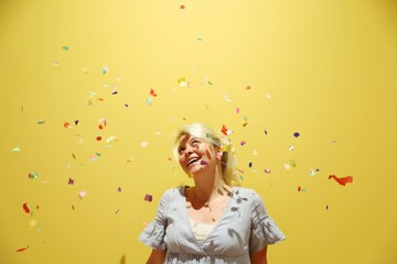 A young happy blond woman against colourful background