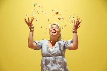 A young happy blond woman against colourful background