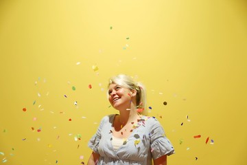 A young happy blond woman against colourful background