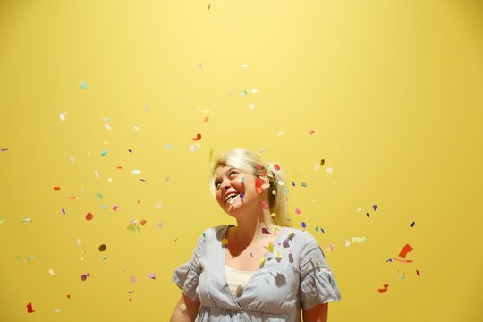 A young happy blond woman against colourful background