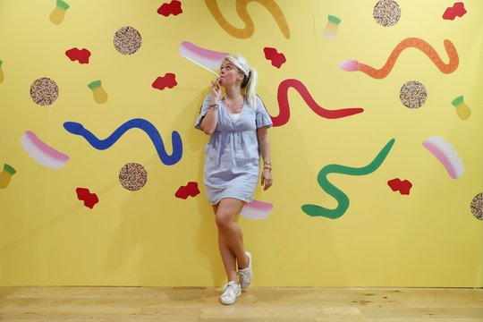 A young happy blond woman against colourful background