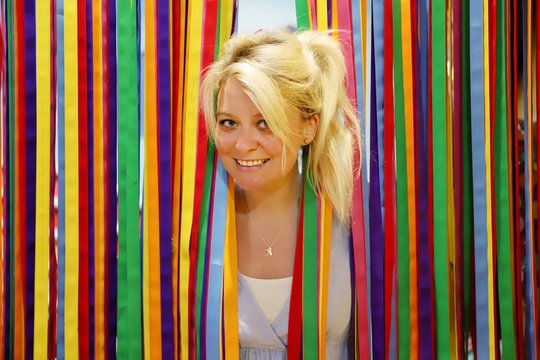 A young happy blond woman against colourful background
